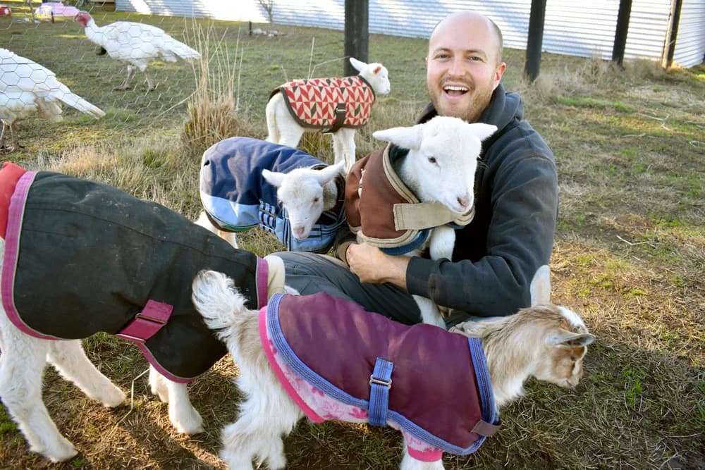 Kyle with baby goats at the sanctuary
